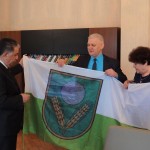 No labās: Rēzeknes novada domes priekšsēdētāja vietniece Elvīra Pizāne un pašvaldības izpilddirektors Jānis Troška pasniedz Rēzeknes novada pašvaldības karogu Agdašas pašvaldībai